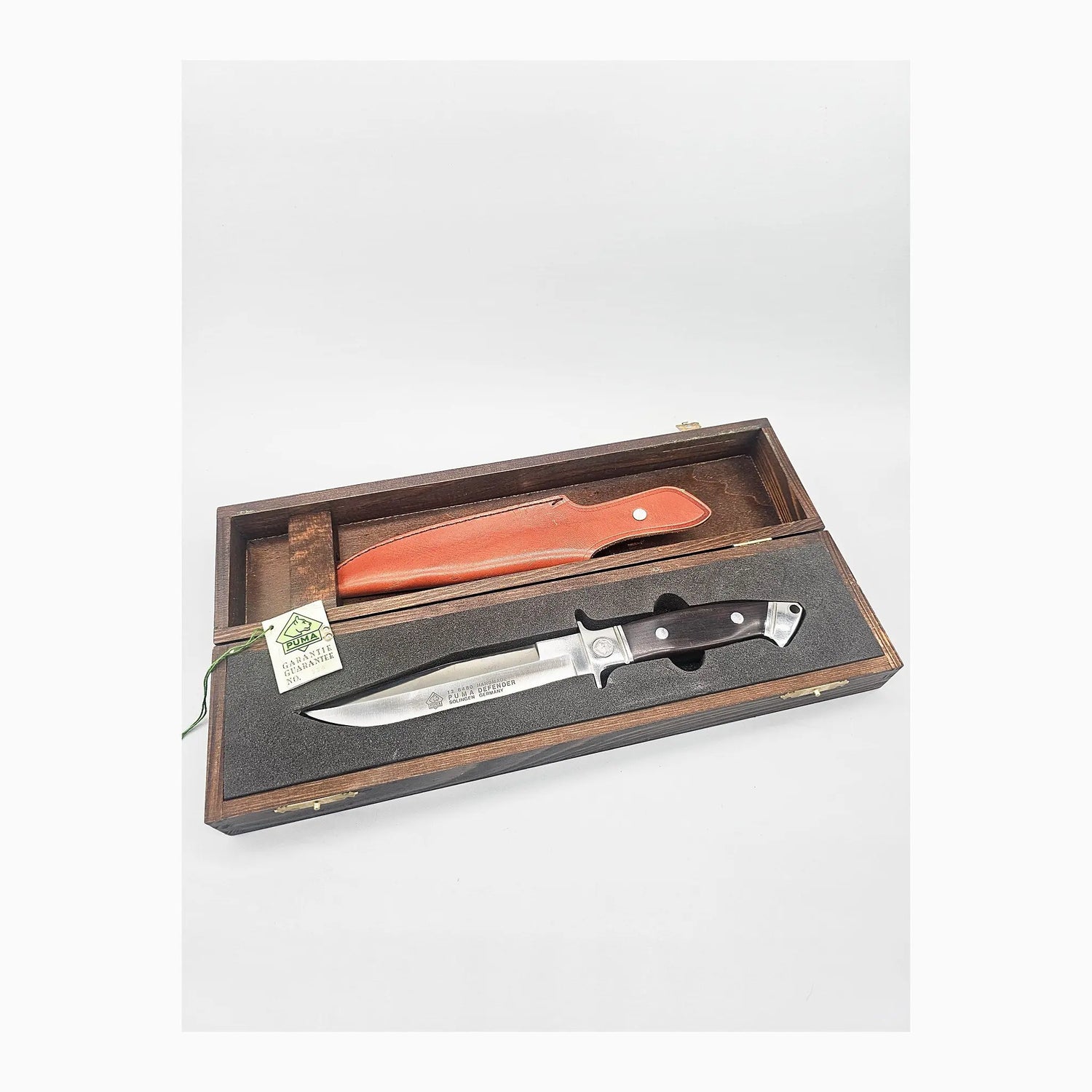 PUMA Defender 336/500 in geöffneter PUMA Holz-Geschenkbox mit Lederscheide und Garantiekarte