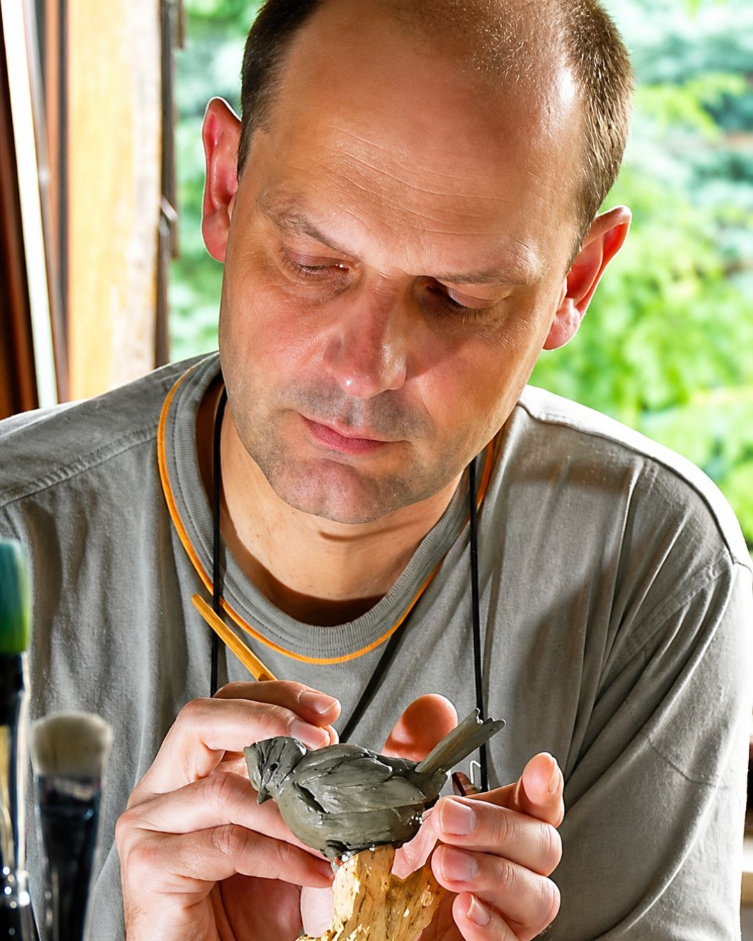 Der Künstler Detlef Ritter modelliert einen Vogel